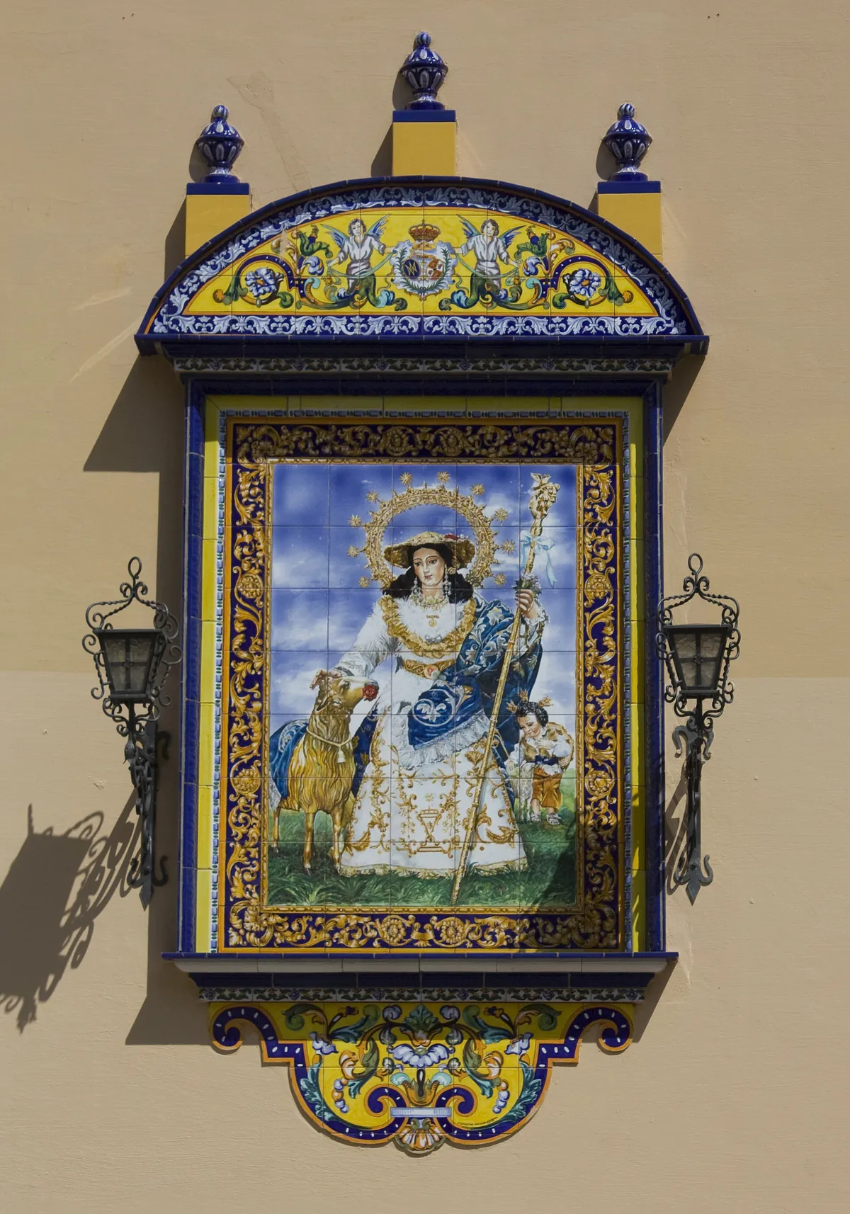 Keramický panel zobrazující Pannu Marii s dítětem ve zdobeném rámu na zdi kostela Santa Ana